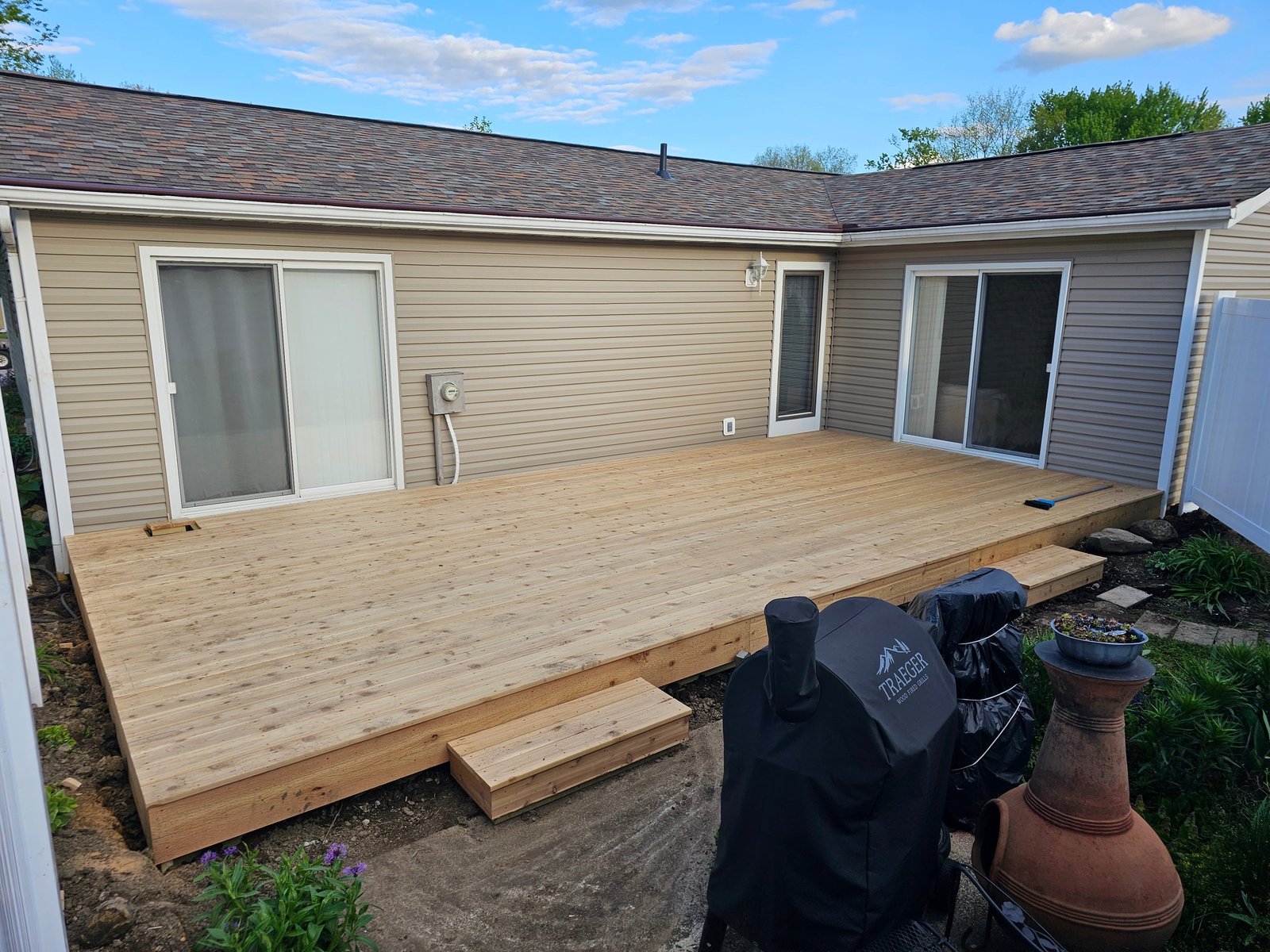 Newly built cedar deck running across the back of a single-storey home